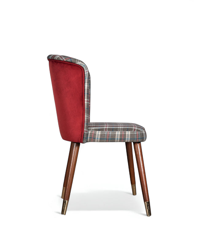 Side view of the Vaya Home Inverto dining chair with checkered upholstery, red outer back, and tapered wood legs with gold caps.