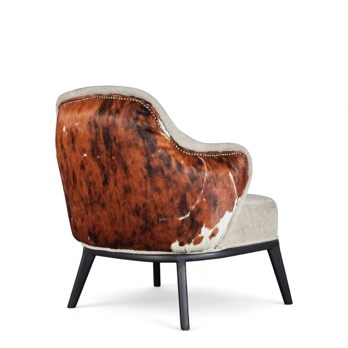 Rear angled view of the Vaya Home Kalv accent chair with a brown cowhide outer back, beige upholstered seat, and black legs.