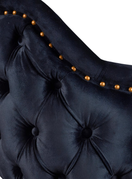 Close-up of the Vaya Home Lila accent chair showing dark blue velvet upholstery, deep button tufting, and nailhead trim detail.