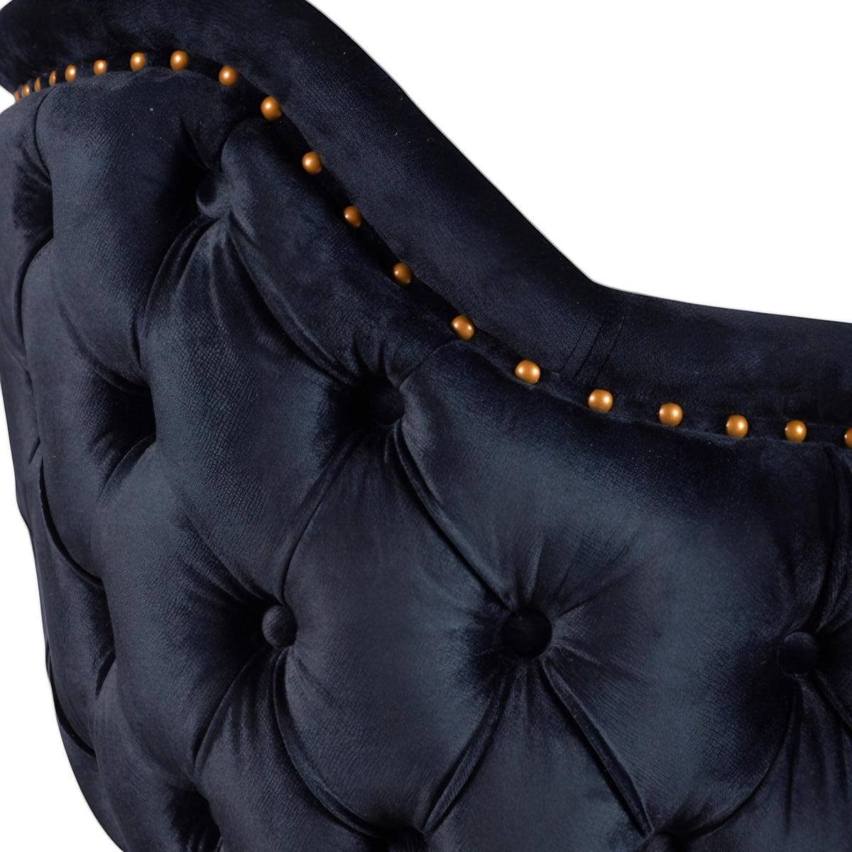 Close-up of the Vaya Home Lila accent chair showing dark blue velvet upholstery, deep button tufting, and nailhead trim detail.
