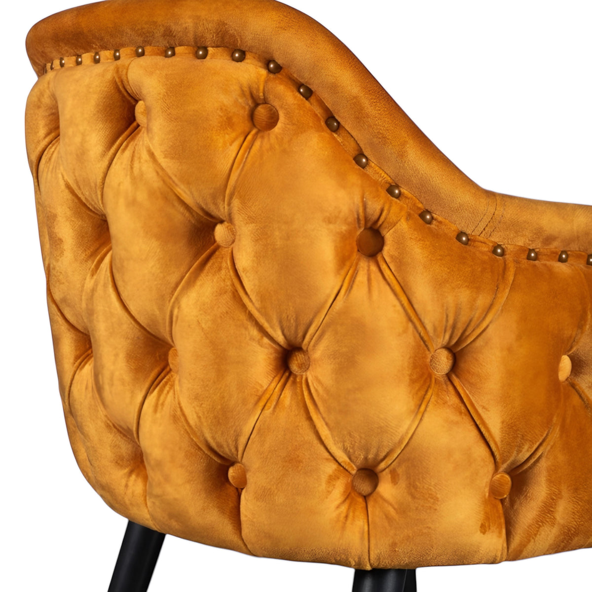 Close-up of the Vaya Home Lila accent chair showing orange velvet upholstery, deep button tufting, and nailhead trim detail.