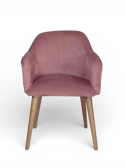 Front angled view of the Vaya Home Lila accent chair with pink velvet upholstery, curved arms, and tapered wood legs.