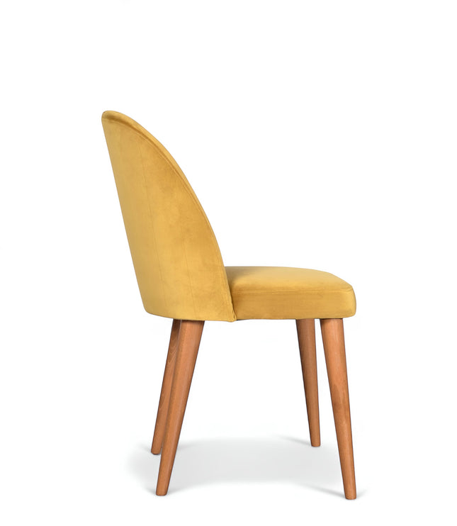 Side view of the Vaya Home Limett dining chair with yellow upholstery, rounded backrest, and tapered wood legs.