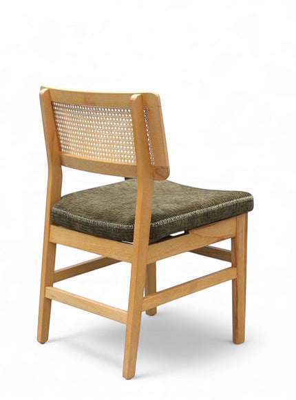 Rear angled view of the Vaya Home Lino dining chair with woven cane back detail, natural wood frame, and upholstered seat.