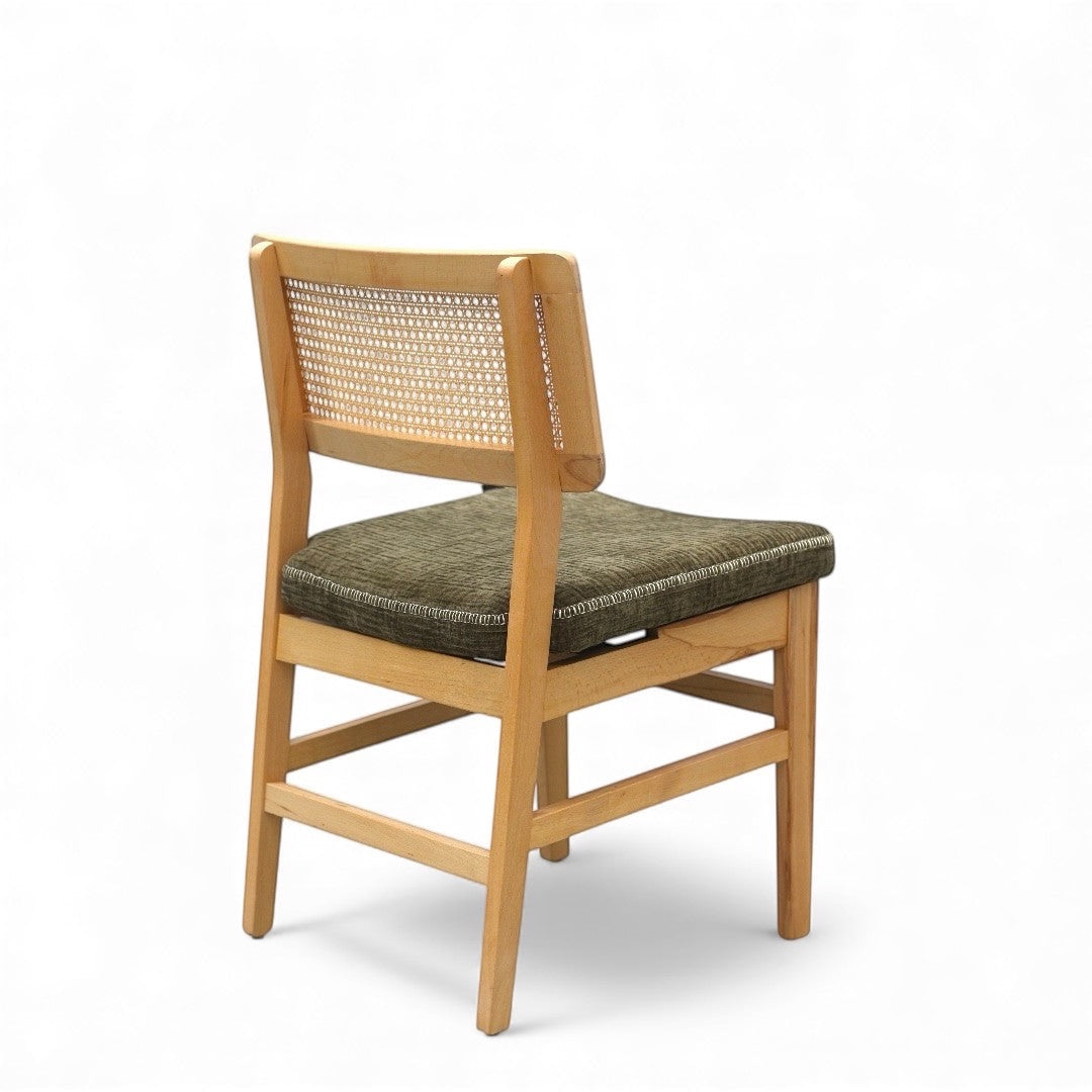 Rear angled view of the Vaya Home Lino dining chair with woven cane back detail, natural wood frame, and upholstered seat.