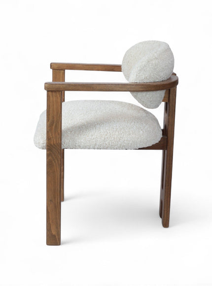 Rear angled view of the Vaya Home Loft dining chair with white boucle upholstery, rounded back cushion, and a warm wood frame.