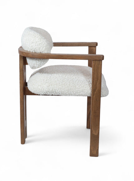 Rear angled view of the Vaya Home Loft dining chair with white boucle upholstery, rounded back cushion, and a warm wood frame.