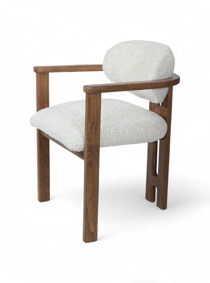 Rear angled view of the Vaya Home Loft dining chair with white boucle upholstery, rounded back cushion, and a warm wood frame.
