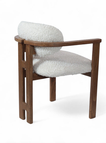 Rear angled view of the Vaya Home Loft dining chair with white boucle upholstery, rounded back cushion, and a warm wood frame.