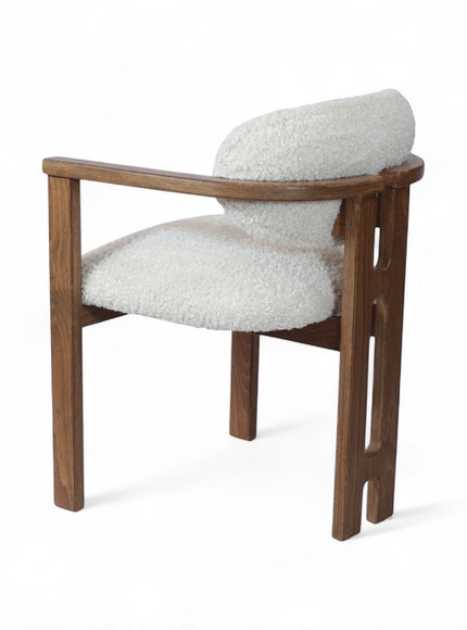 Rear angled view of the Vaya Home Loft dining chair with white boucle upholstery, rounded back cushion, and a warm wood frame.