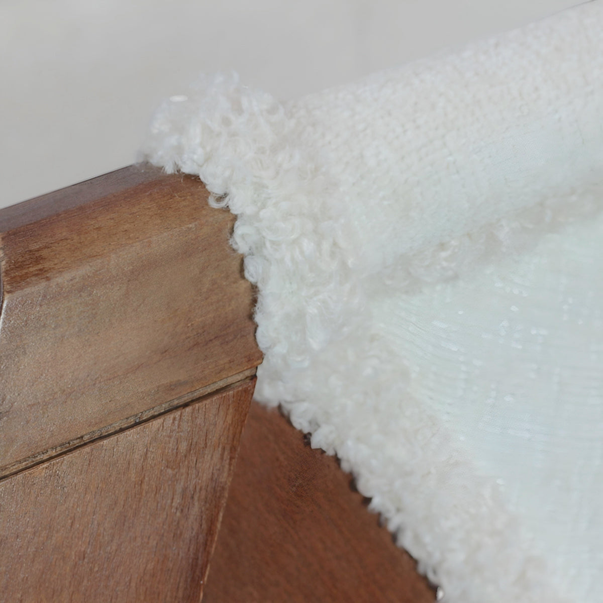 Close-up of the Vaya Home Masiccio dining chair showing white boucle upholstery and wood frame detail.