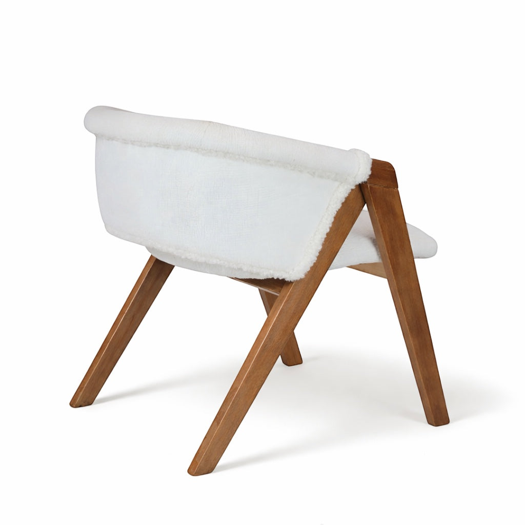 Rear angled view of the Vaya Home Masiccio dining chair with white boucle upholstery and a warm wood frame.