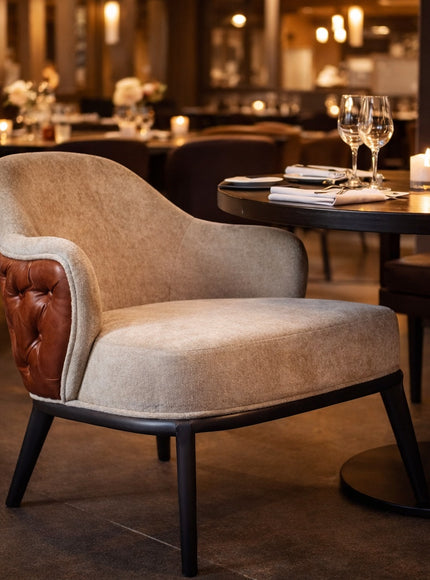 Vaya Home Mattonne accent chair with beige upholstery, a tufted burgundy outer back, and black legs, styled in an elegant dining setting.