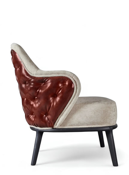 Side view of the Vaya Home Mattonne accent chair featuring beige upholstery, a tufted burgundy outer back, curved arms, and black legs.