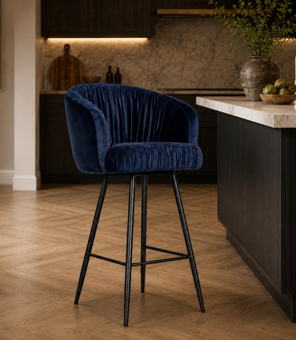 Vaya Home Midnight bar stool with dark blue velvet upholstery and a black metal base, styled at a modern kitchen island.