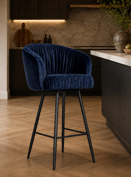 Vaya Home Midnight bar stool with dark blue velvet upholstery and a black metal base, styled at a modern kitchen island.