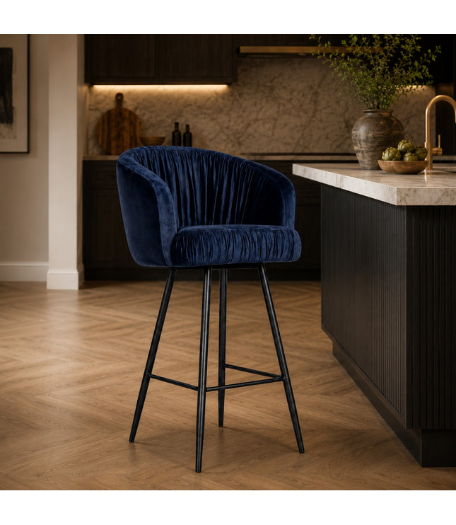 Vaya Home Midnight bar stool with dark blue velvet upholstery and a black metal base, styled at a modern kitchen island.