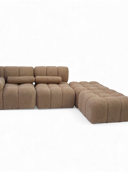 Angled view of the Vaya Home Moducube modular sectional sofa with beige boucle upholstery and matching ottoman.