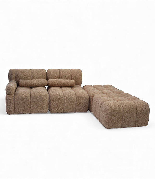 Angled view of the Vaya Home Moducube modular sectional sofa with beige boucle upholstery and matching ottoman.