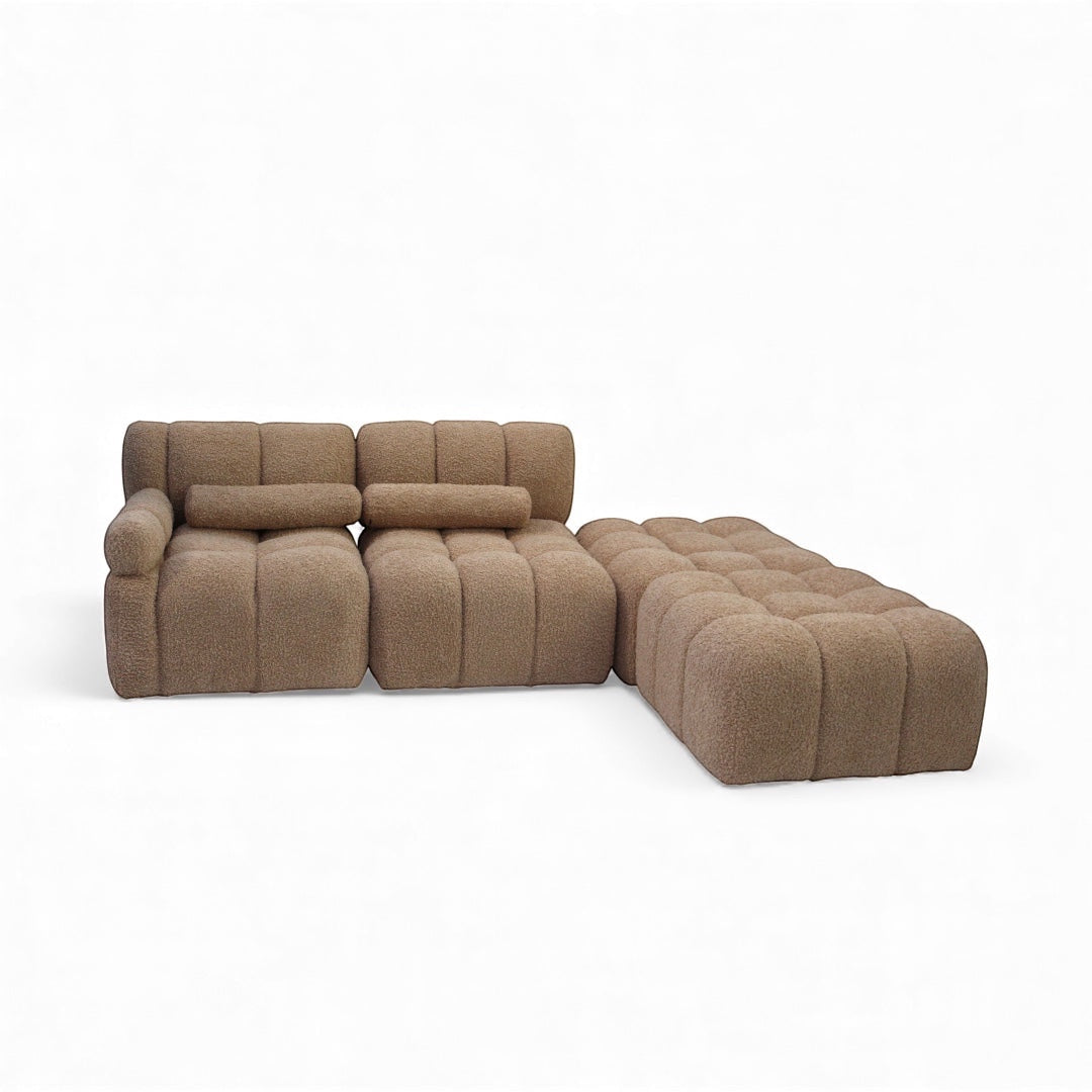 Angled view of the Vaya Home Moducube modular sectional sofa with beige boucle upholstery and matching ottoman.