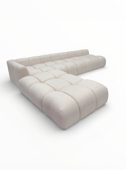 Perspective view of the Vaya Home Monolith sectional sofa with sculpted modular form and cream upholstered cushioning.