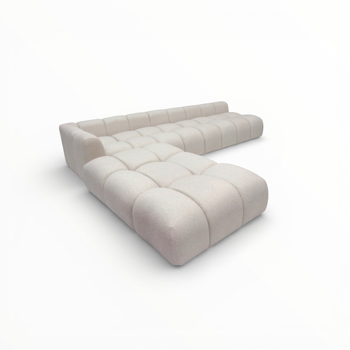 Perspective view of the Vaya Home Monolith sectional sofa with sculpted modular form and cream upholstered cushioning.