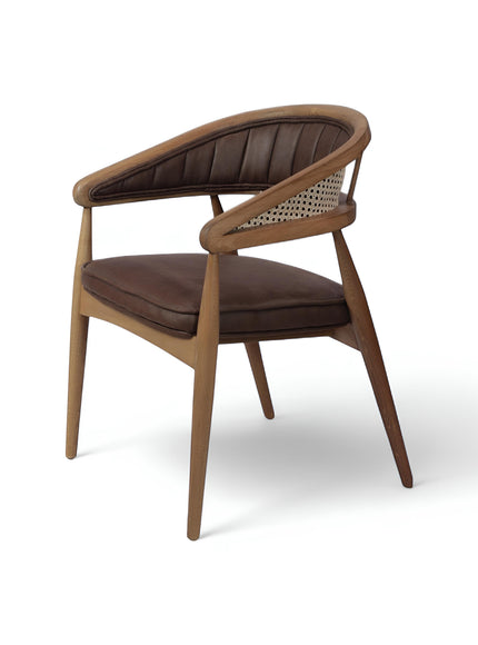 Front angled view of the Vaya Home Morbido dining chair with a woven cane back, dark brown seat cushion, and curved wood frame.