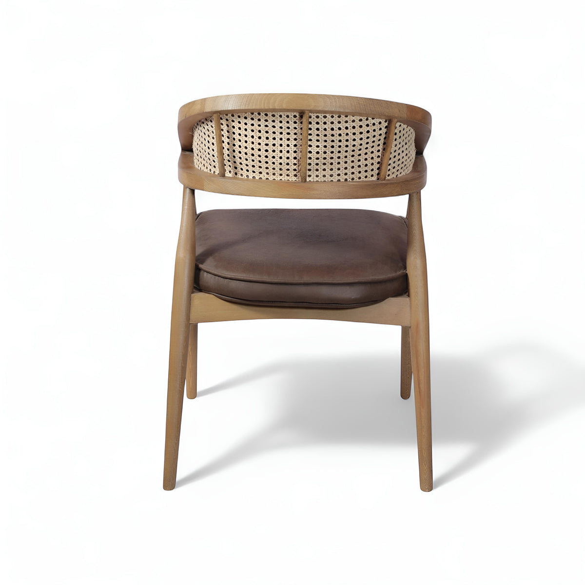 Rear angled view of the Vaya Home Morbido dining chair with a woven cane back, dark brown seat cushion, and curved wood frame.