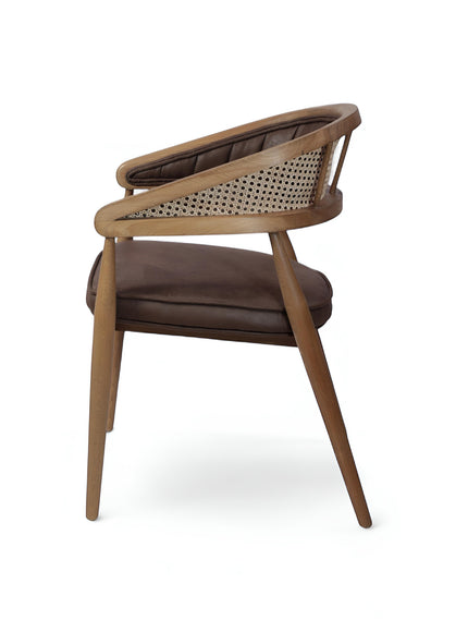 Rear angled view of the Vaya Home Morbido dining chair with a woven cane back, dark brown seat cushion, and curved wood frame.