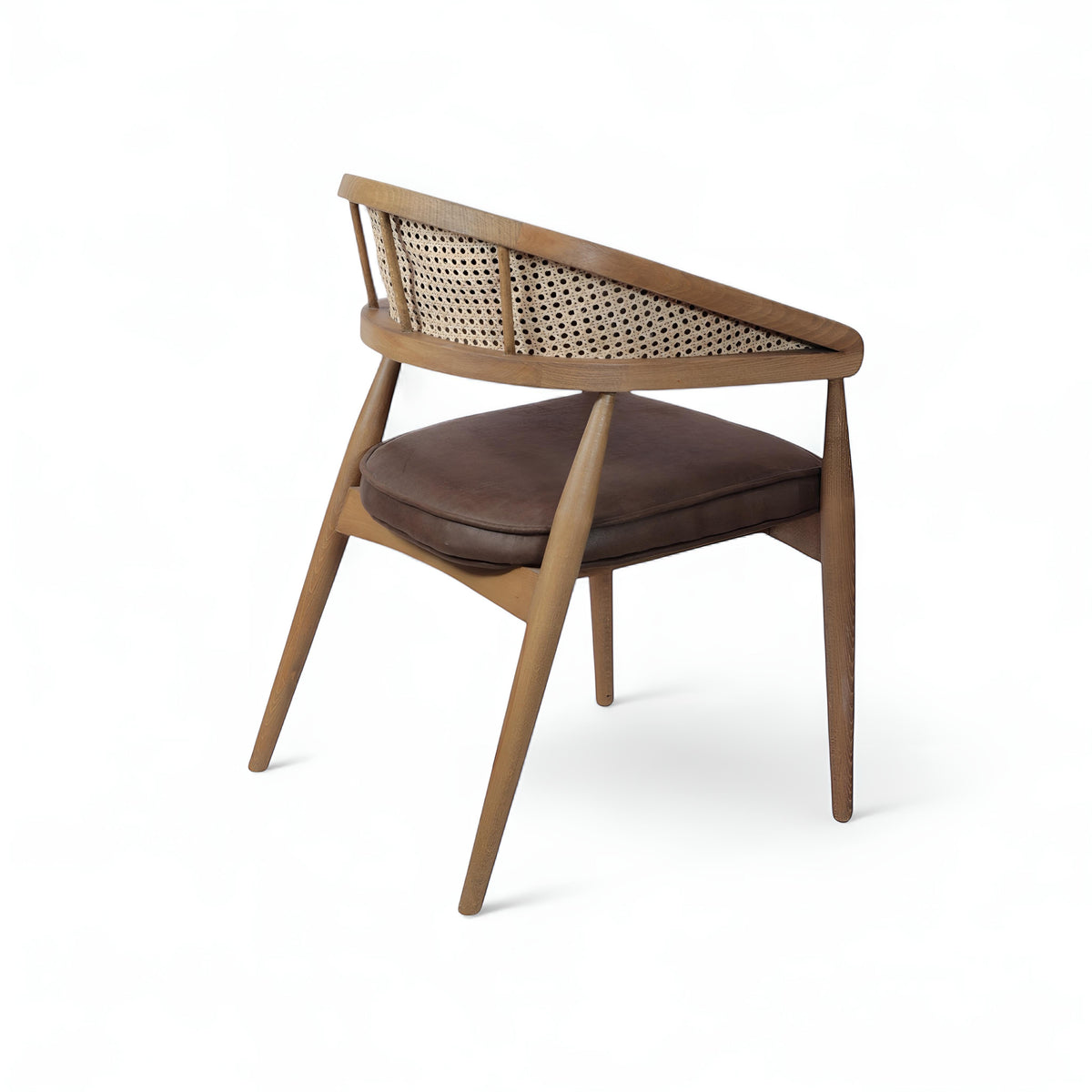 Rear angled view of the Vaya Home Morbido dining chair with a woven cane back, dark brown seat cushion, and curved wood frame.