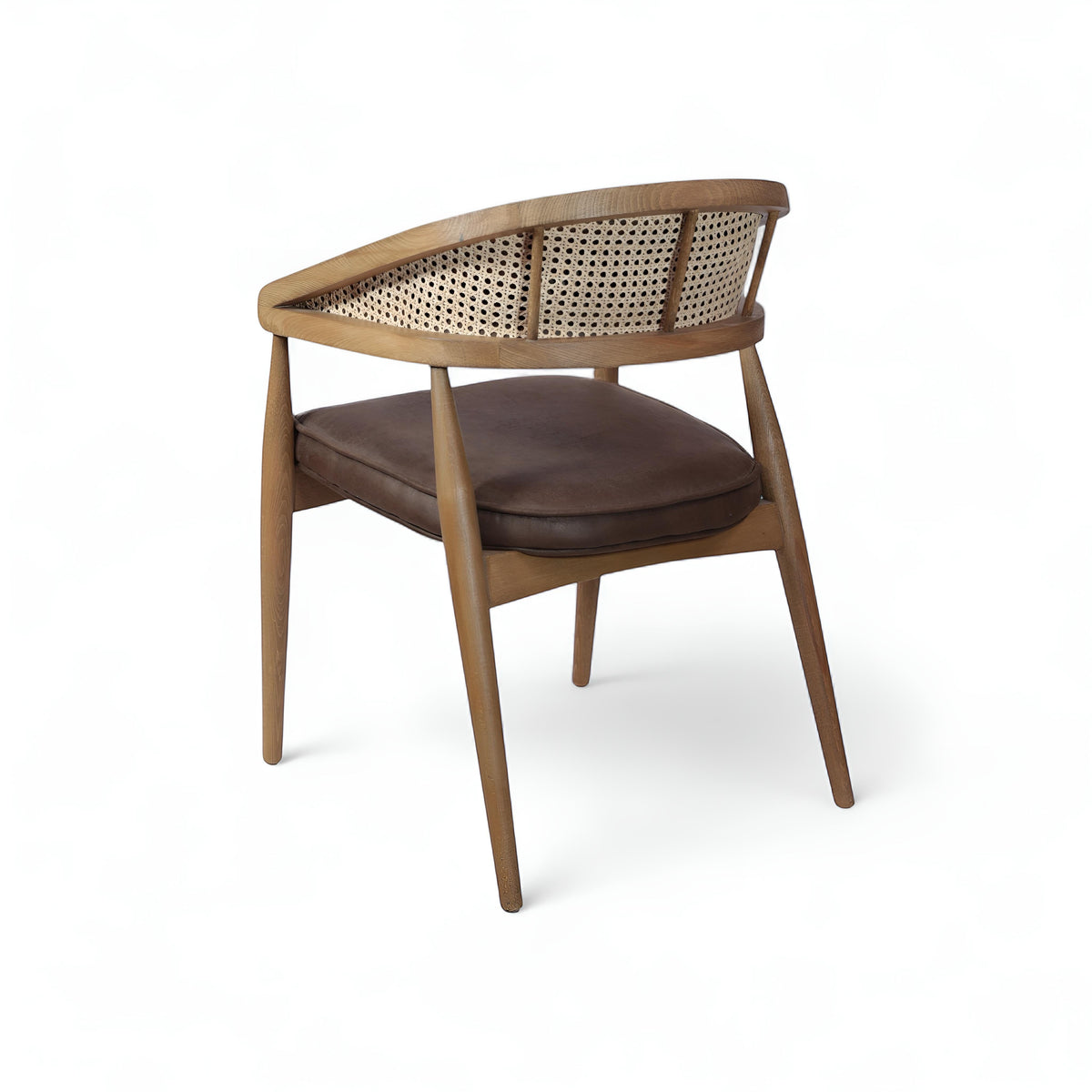 Rear angled view of the Vaya Home Morbido dining chair with a woven cane back, dark brown seat cushion, and curved wood frame.