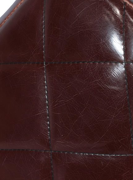 Close-up of the Vaya Home Morkrod bar stool showing dark brown quilted upholstery detail.