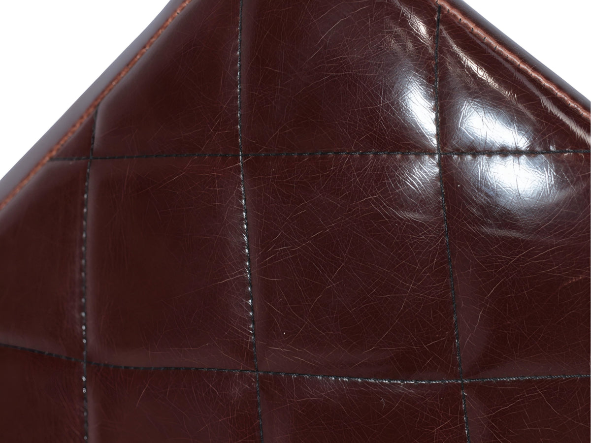 Close-up of the Vaya Home Morkrod bar stool showing dark brown quilted upholstery detail.