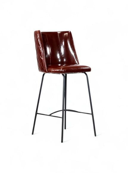 Front angled view of the Vaya Home Morkrod bar stool with rose gold quilted upholstery and black metal legs.