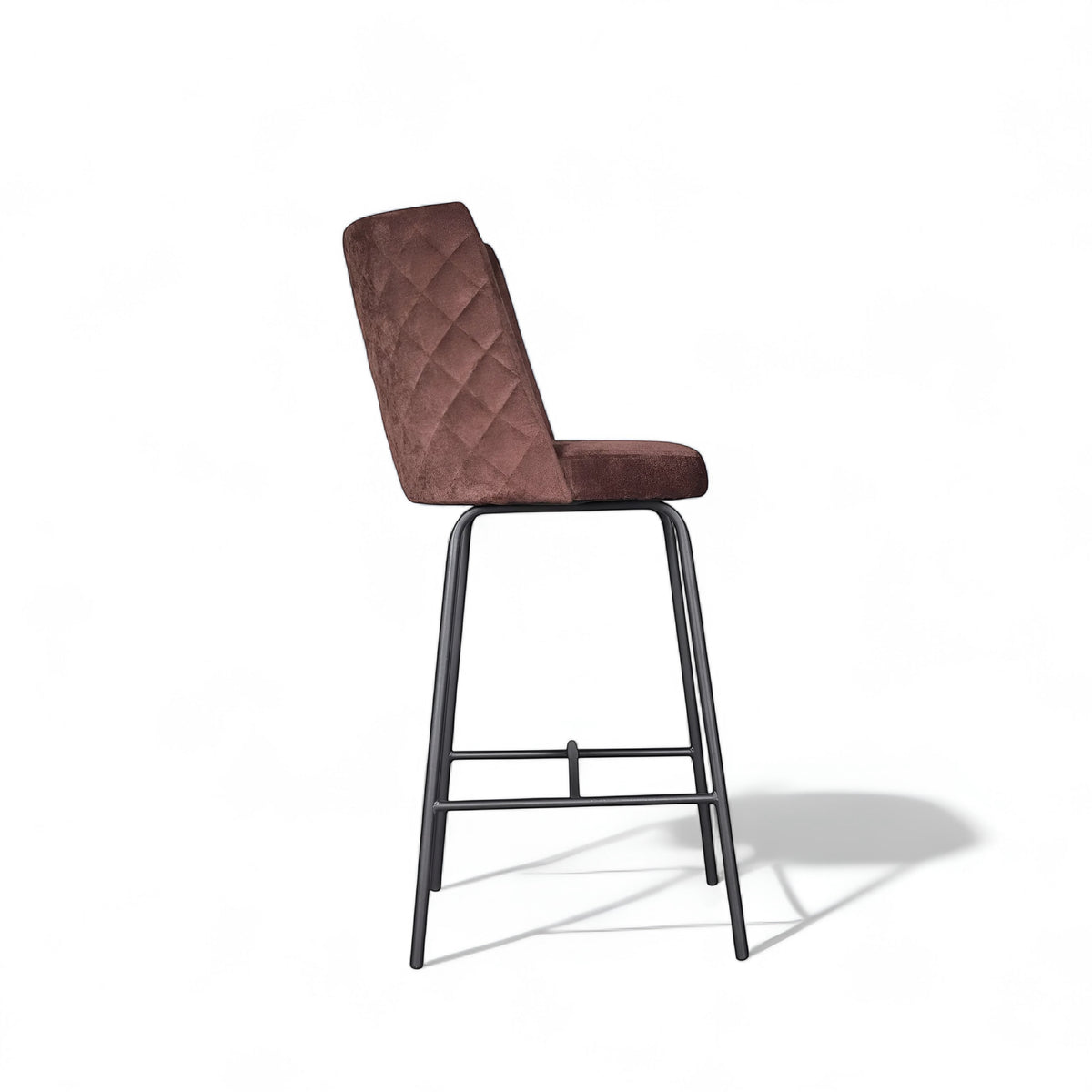 Side view of the Vaya Home Morkrod bar stool featuring rose gold quilted upholstery and black metal legs.