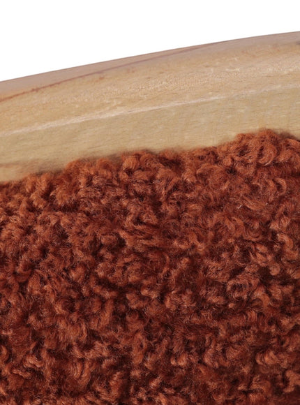 Close-up of the Vaya Home Mouton dining chair showing orange boucle upholstery and wood frame detail.