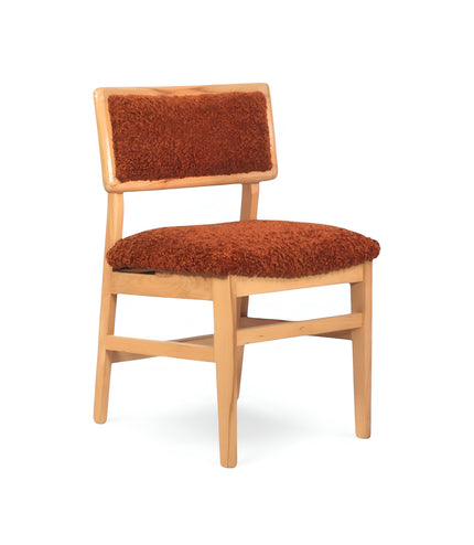 Front angled view of the Vaya Home Mouton dining chair featuring orange boucle upholstery and a natural wood frame.