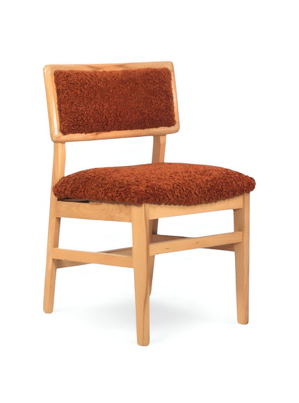 Front angled view of the Vaya Home Mouton dining chair featuring orange boucle upholstery and a natural wood frame.