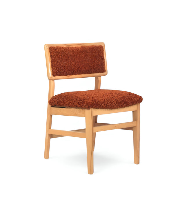 Front angled view of the Vaya Home Mouton dining chair featuring orange boucle upholstery and a natural wood frame.
