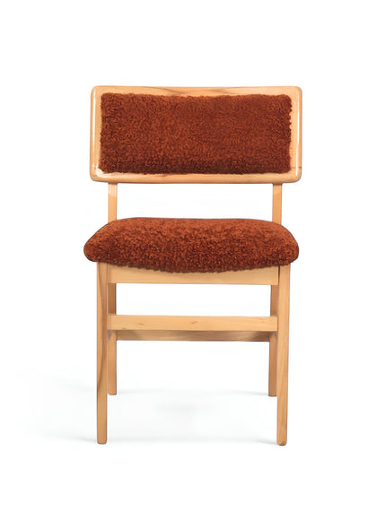 Front view of the Vaya Home Mouton dining chair with orange boucle upholstery and a natural wood frame.