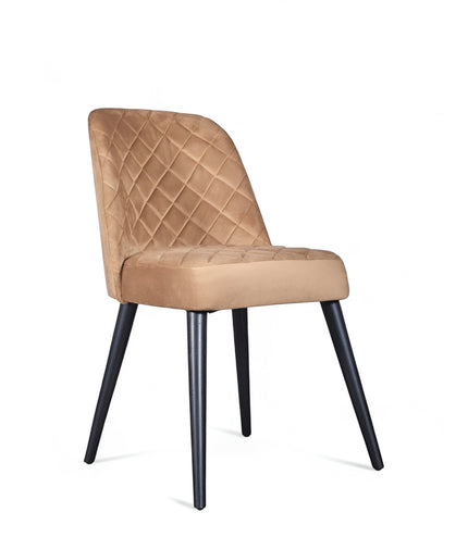 Front angled view of the Vaya Home Netto dining chair with beige upholstery, quilted back detail, and black tapered legs.