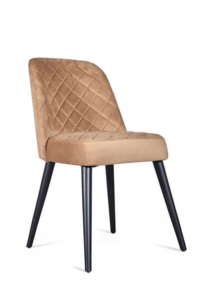 Front angled view of the Vaya Home Netto dining chair with beige upholstery, quilted back detail, and black tapered legs.