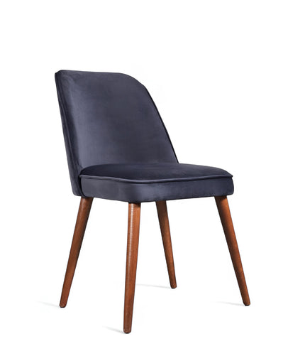 Front angled view of the Vaya Home Netto dining chair with dark blue upholstery, cushioned seat, and tapered wood legs.