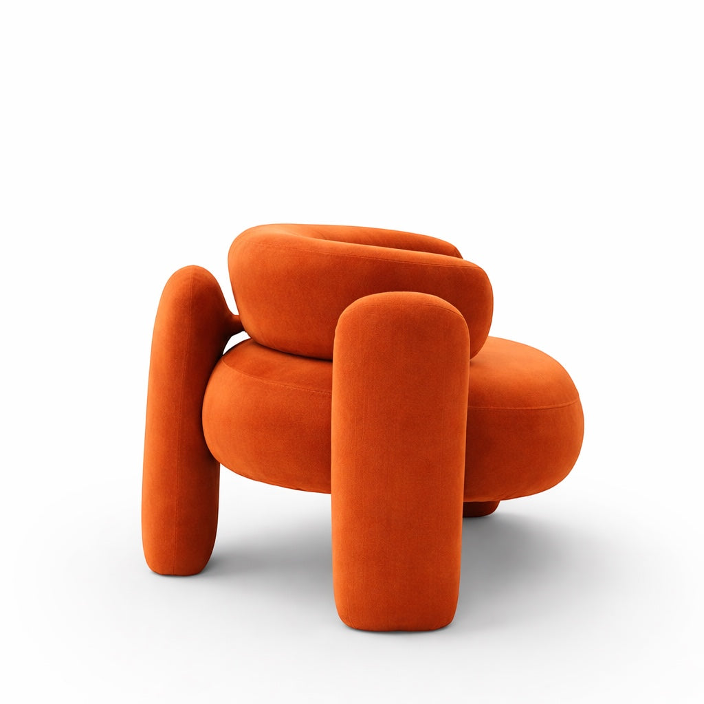 Side view of the Vaya Home Orbit accent chair featuring a sculptural silhouette, curved arms, and orange upholstery.