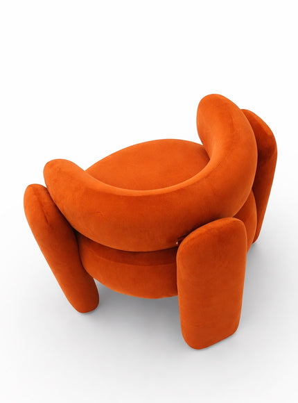 Top angled view of the Vaya Home Orbit accent chair showing its rounded seat, wraparound backrest, and sculptural orange upholstered legs.
