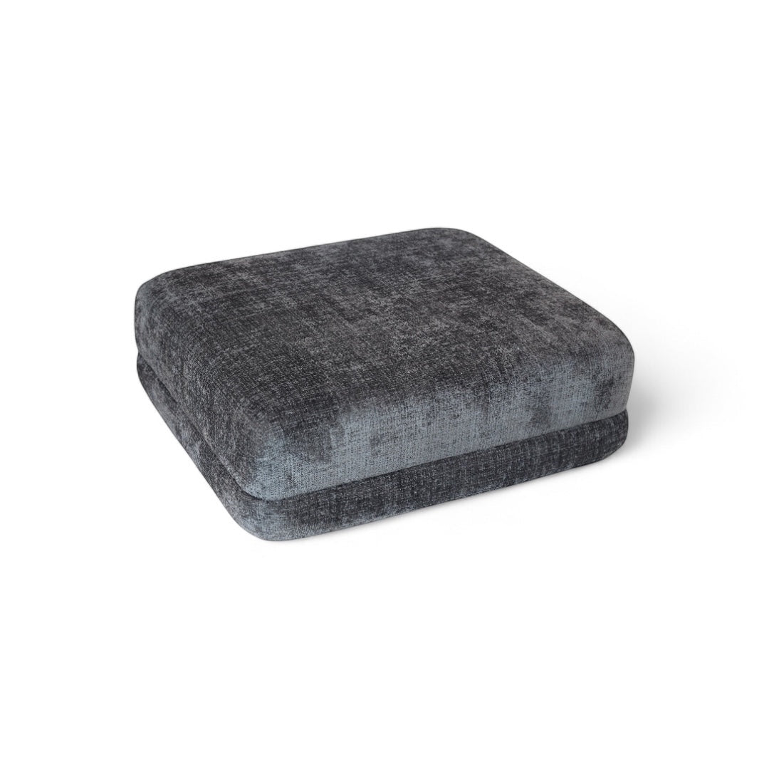 Angled view of the Vaya Home Origin ottoman in charcoal textured upholstery.