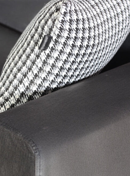 Close-up of the Vaya Home Pacco sofa showing grey upholstery, seam detailing, and accent cushion texture.