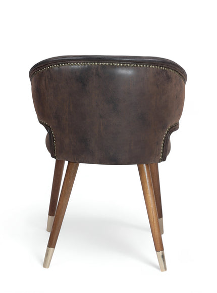 Back view of the Vaya Home Pelle accent chair featuring dark brown upholstery, a rounded back, and tapered wood legs with metal caps.