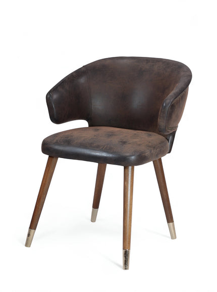 Front angled view of the Vaya Home Pelle accent chair featuring dark brown leather-look upholstery, sculpted arms, and tapered wood legs with metal caps.