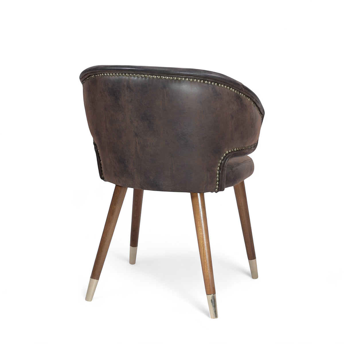 Opposite rear angled view of the Vaya Home Pelle accent chair with dark brown upholstery, nailhead trim, and tapered wood legs with metal caps.